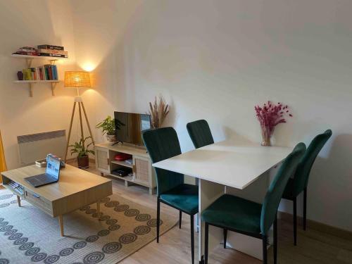 a living room with a table and chairs and a laptop at Zen and chill F2 appartment and garden near Paris in Chelles