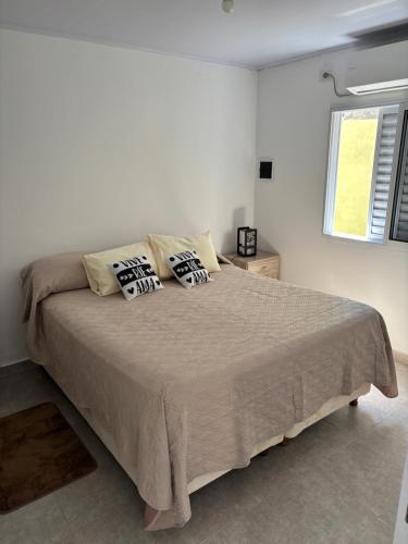 a white bedroom with a large bed with pillows at RoMa in Reconquista