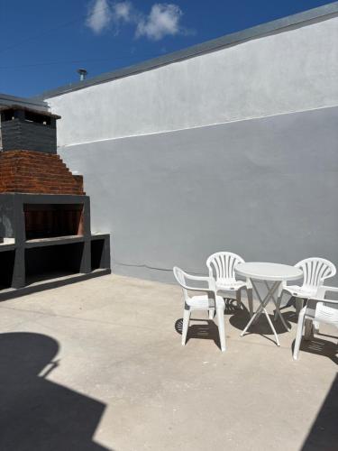 a patio with chairs and a table and a wall at RoMa in Reconquista