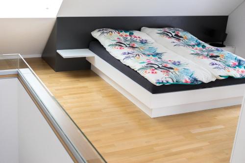 a white bed with a floral blanket on it at L19 Tuttlingen in Tuttlingen