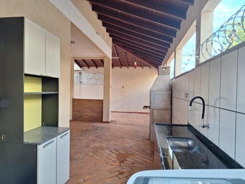 a kitchen with white cabinets and a brick floor at bairro Amambai - sobrado com 5 quartos e 5 banheiros in Campo Grande