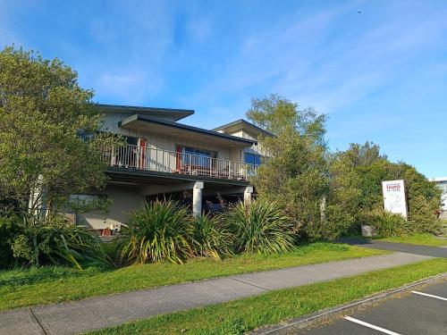 a apartment building with a balcony and a parking lot at Adventure Taupō Hostel in Taupo