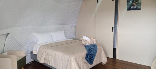 een kleine slaapkamer met een bed met witte lakens bij La cabaña de Ciela Glamping con jacuzzi in Latacunga