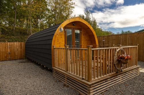 a small wooden cabin with a wooden fence at livi pod Woodland lake in Carlton Miniott