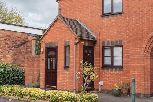 a red brick house with a wooden door at Wellington Modern Studio - Free Parking in Wellington