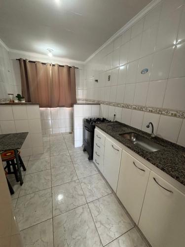 a small kitchen with a sink and a stove at Apartamento próximo ao inhotim in Brumadinho