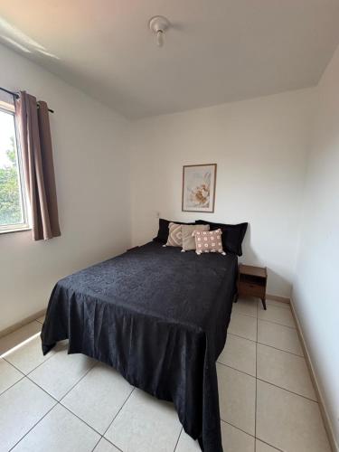 a bedroom with a bed with a black blanket at Apartamento próximo ao inhotim in Brumadinho