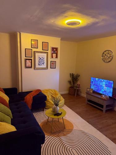 a living room with a blue couch and a tv at Grand Haven Dudley in Dudley