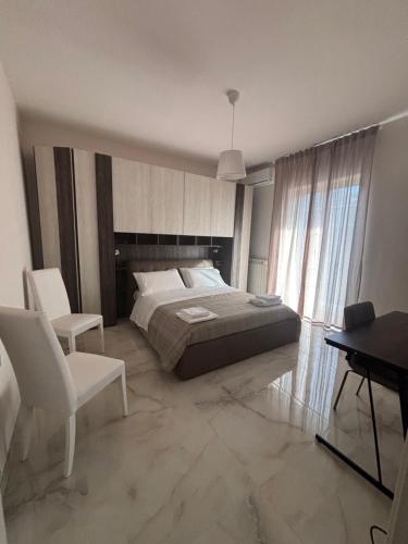 a bedroom with a bed and a table and chairs at a&g partenope in Monterusciello