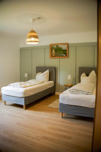 a bedroom with two beds and a pendant light at Ferienwohnung Peters (EG) in Hünfeld
