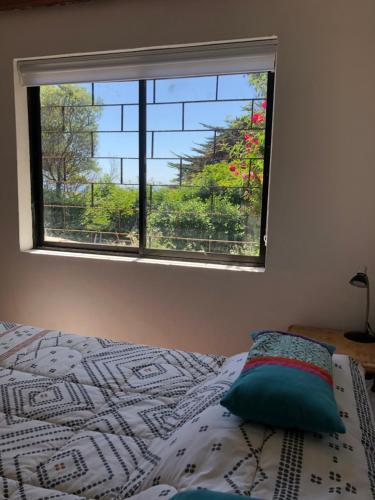 a bedroom with a bed and a window with a view at Chalet Bordemar in Concón