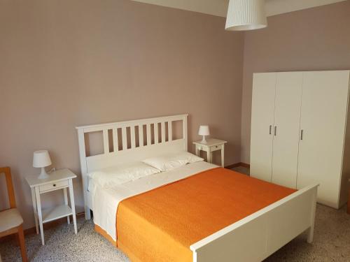 セニガッリアにあるAppartamento Federicaのベッドルーム1室(大型ベッド1台、テーブル2台付)