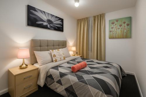 une chambre avec un lit avec un oreiller orange dessus dans l'établissement Stylish Platt bridge contractor Stays, à Abram