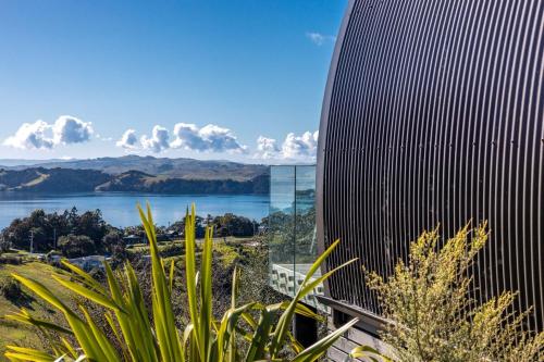 a tall building with a view of a body of water at Perch on the Ridge by Waiheke Pure in Waiheke Island