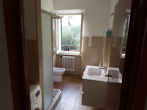 baño con lavabo y aseo y ventana en Appartamento Federica, en Senigallia