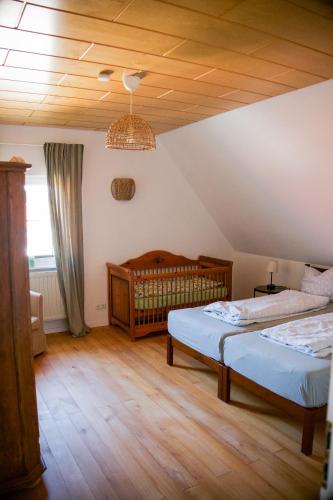 a bedroom with two beds and a baby crib at Ferienwohnung Peters in Hünfeld