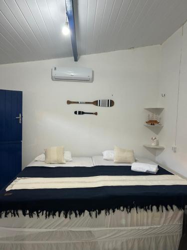 a bedroom with a bed in a white room at Suite Canoa Azul Broadway in Aracati