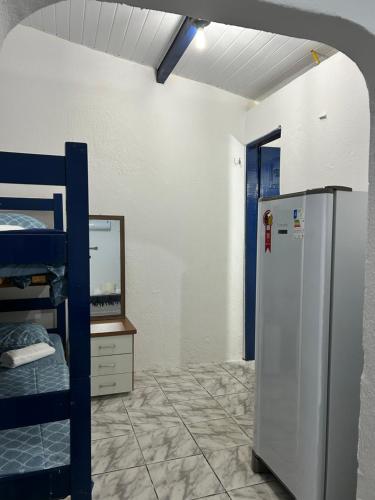 a room with a refrigerator and a bunk bed at Suites a 5min da Broadway in Aracati