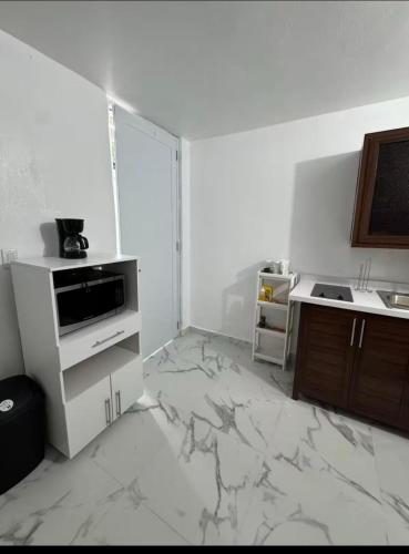 a white kitchen with a marble floor and a counter at Hospedaje paz y amor in San Juan
