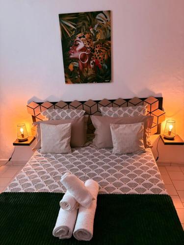 een slaapkamer met een bed met twee handdoeken erop bij Le Neo-Cayenne in Cayenne