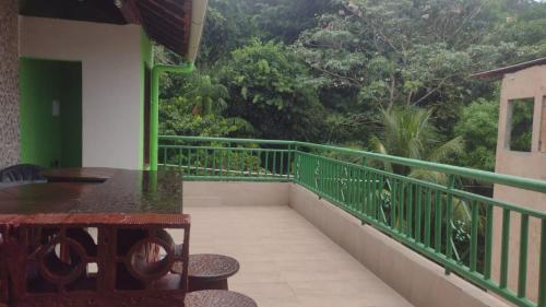a balcony with a table and chairs and trees at Quarto para cop30 em casa de família in Belém