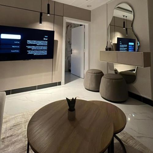 een woonkamer met een houten tafel en een tv bij نور هوستيل in Riyad