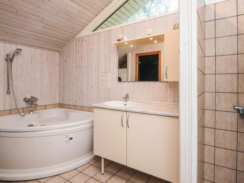 a bathroom with a tub and a sink and a toilet at 8 person holiday home in Fanø-By Traum in Fanø