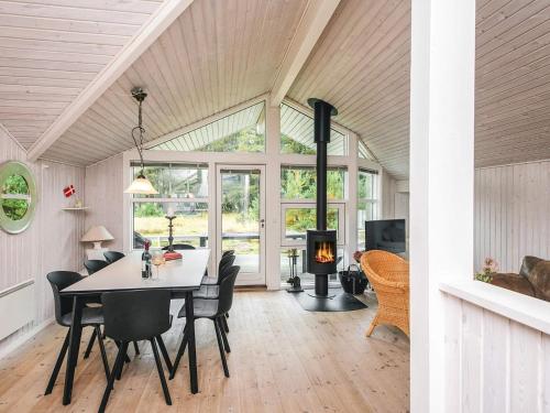 a dining room with a table and chairs and a fireplace at 8 person holiday home in Fanø-By Traum in Fanø