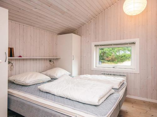 a large bed in a room with a window at 8 person holiday home in Fanø-By Traum in Fanø
