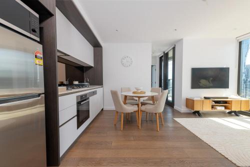 a kitchen and dining room with a table and chairs at Flinders St Central - Parking, Gym, Pool & Sauna in Melbourne