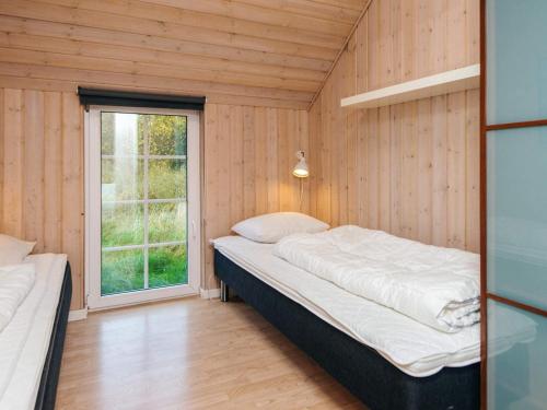 a small bedroom with a bed and a window at Luxury Retreat with Pool - By Traum Ferienwohnungen in Fanø