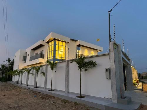 a building with palm trees in front of it at Modern and luxurious villa, comfort and tranquility in Saly Portudal