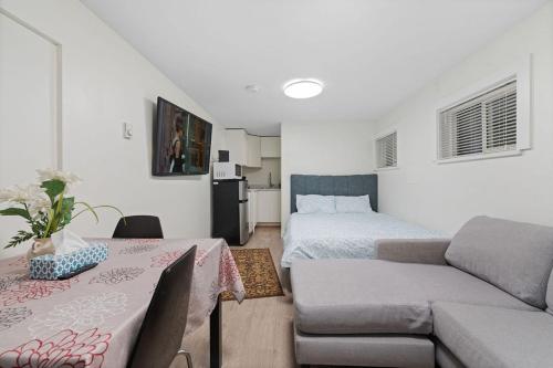una stanza con un letto, un divano e un tavolo di Renovated North Vancouver Gem a North Vancouver