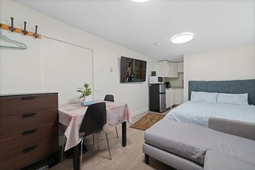 a bedroom with a bed and a table and a desk at Renovated North Vancouver Gem in North Vancouver
