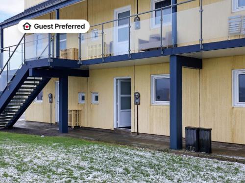a apartment building with a staircase and a snow covered yard at 4 person holiday home in Løkken in Løkken