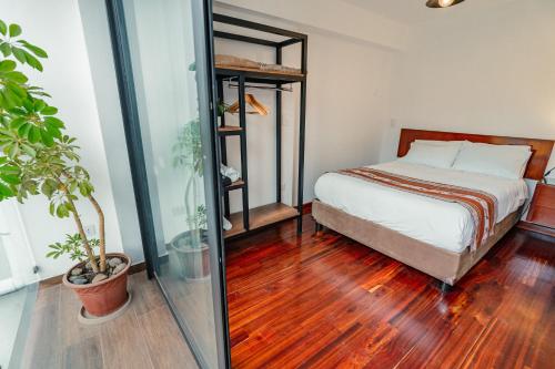 een slaapkamer met een bed en een houten vloer bij Apartamento con todo cerca en Cusco in Cuzco