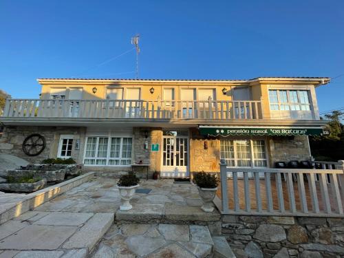 een geel huis met een balkon erbovenop bij Casa Os Batáns in Vimianzo