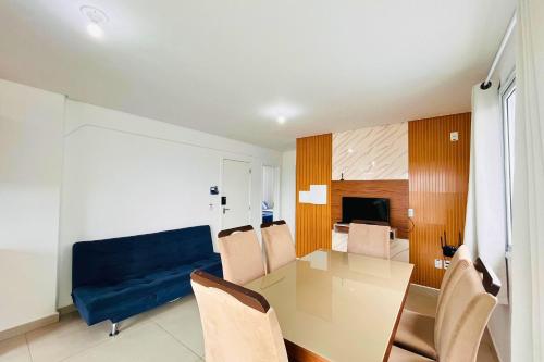 ein Wohnzimmer mit einem Tisch und einem blauen Sofa in der Unterkunft Captiva Beach - 400m da PRAIA - WiFi - Vaga Coberta in Navegantes
