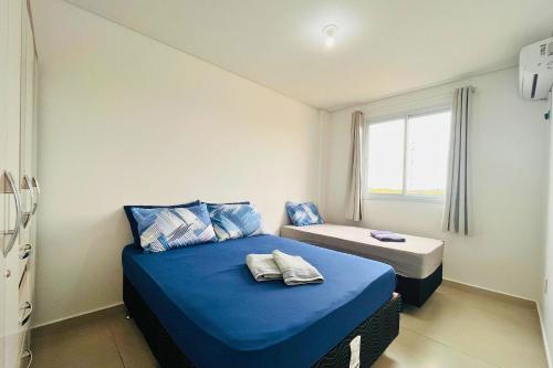 ein kleines Zimmer mit zwei Betten und einem Fenster in der Unterkunft Captiva Beach - 400m da PRAIA - WiFi - Vaga Coberta in Navegantes