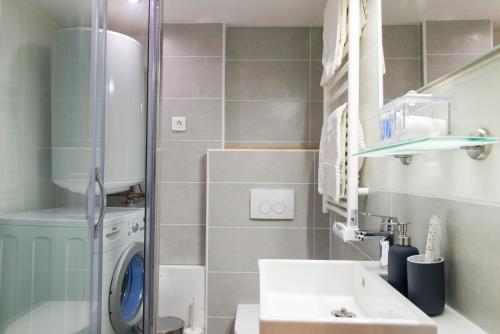 une salle de bain avec un lavabo et une machine à laver dans l'établissement Unsejouranantes - Le Magellan, à Nantes