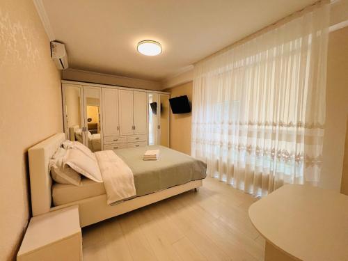 a bedroom with a bed and a large window at Apartament new in Chişinău