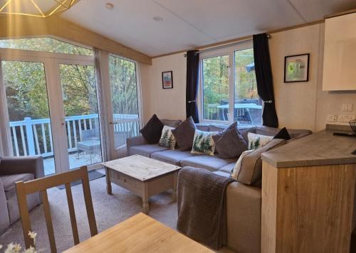 ein Wohnzimmer mit Sofa und Tisch in der Unterkunft The Treehouse Northumberland in Swarland