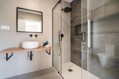 Un baño con ducha con lavabo y espejo. en Ermal Terrace, en Vieira do Minho