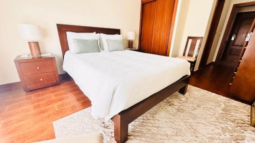 a bedroom with a large bed with a wooden headboard at Residencial A Cista in Vila da Ponte