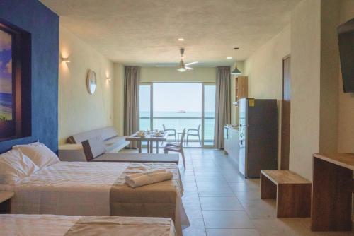 ein Hotelzimmer mit Küche und Wohnzimmer in der Unterkunft Avenir Armonia Suites in Rincón de Guayabitos