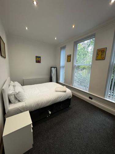 a bedroom with a large bed and a window at No 4 AT SANDRINGHAM - LARGE 2 BED NEAR SEFTON PARK in Liverpool