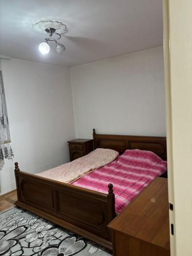 a bedroom with a bed with a pink blanket at Apartman Zaki luxury in Borča