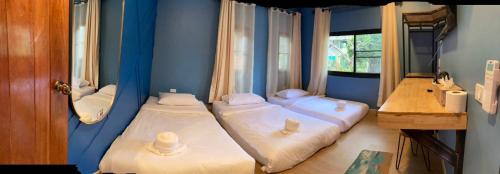 Dos camas en una habitación con paredes azules. en P&P at Pai, en Pai