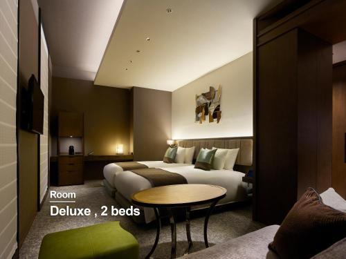a hotel room with a bed and a table at Hotel The Celestine Ginza in Tokyo