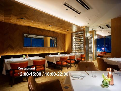 a dining room with white tables and chairs at Hotel The Celestine Ginza in Tokyo